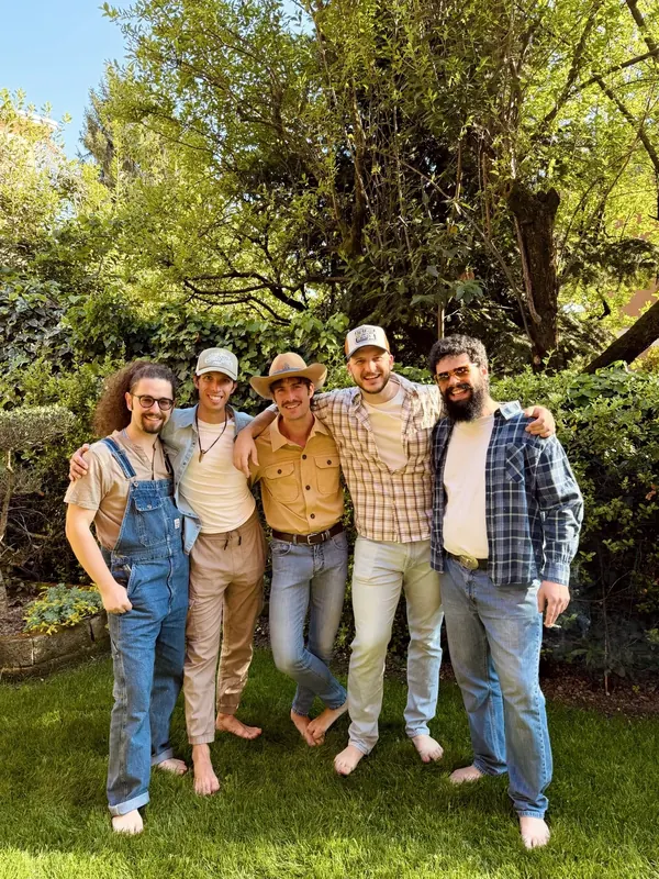 The whole country band in a garden, between sunshine and trees