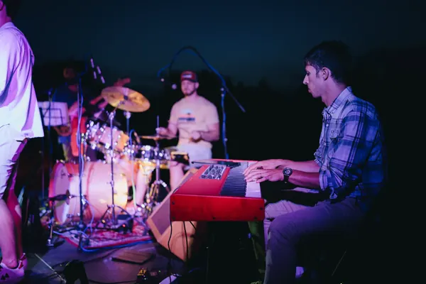 Larry alla tastiera Nord rossa con la band alle spalle durante un live all'imbrunire