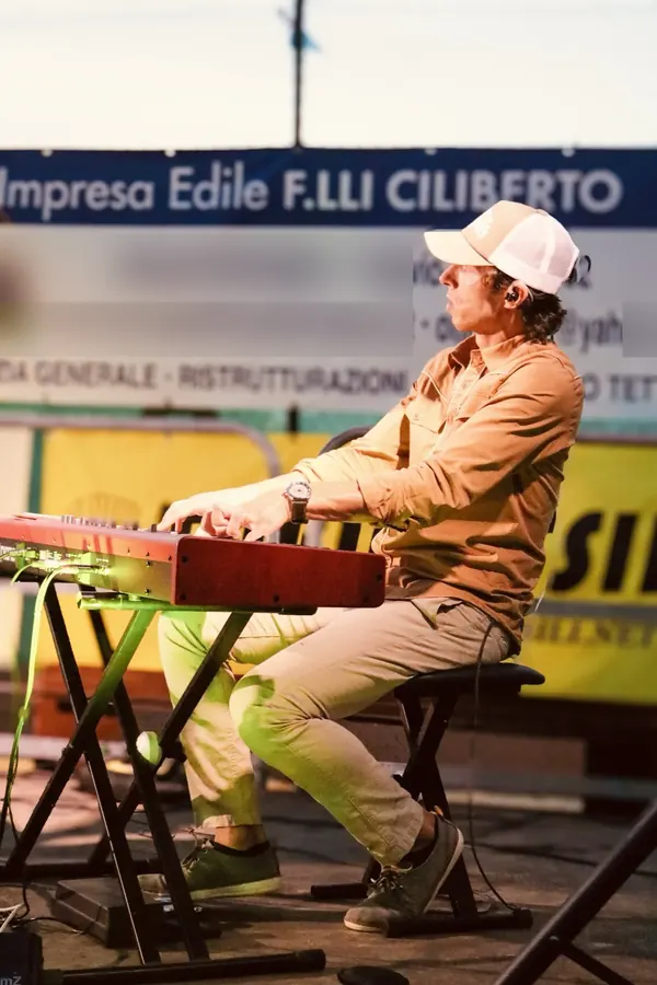 Larry at his red Nord keyboard during a country show at sunset