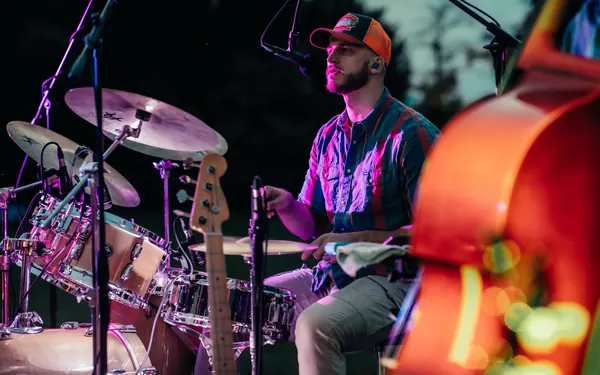 Miglio in purple light behind the drums, the double bass blurred in the foreground