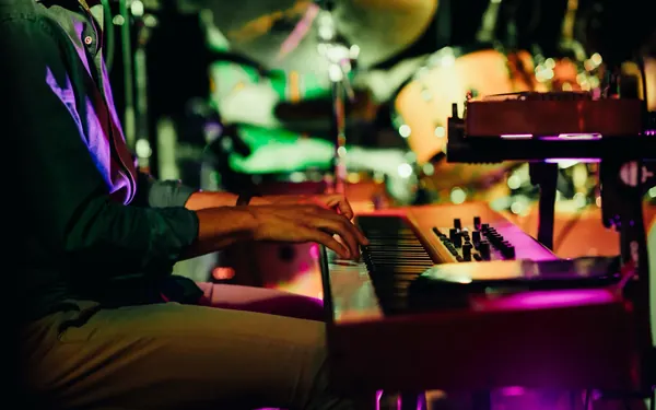 Larry&rsquo;s hands on the keys during a show, green and purple lights behind