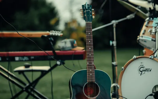 Acoustic guitar, keyboard and Gretsch drums ready on the grass before a country show