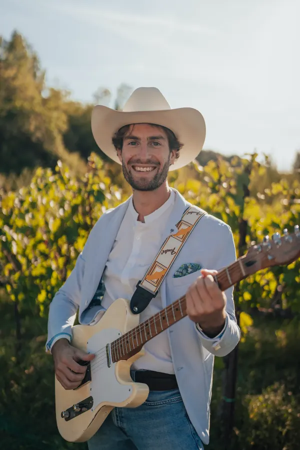 Mike in a country hat with his Telecaster among the vines at sunset