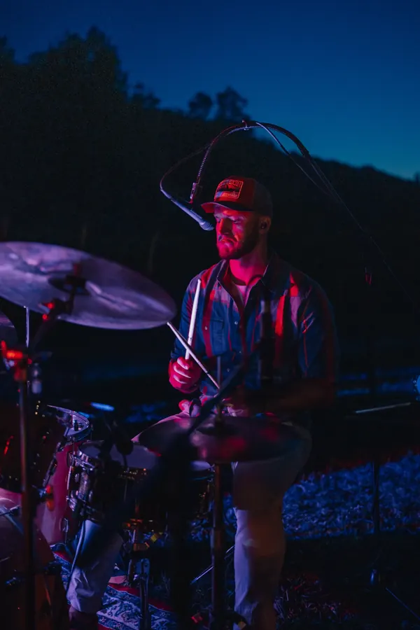 Miglio on drums during an evening show in a vineyard, in pink stage light
