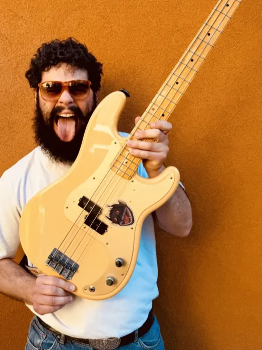 Riccardo “Richi” Loda che alza il basso con la lingua di fuori, davanti a un muro arancio